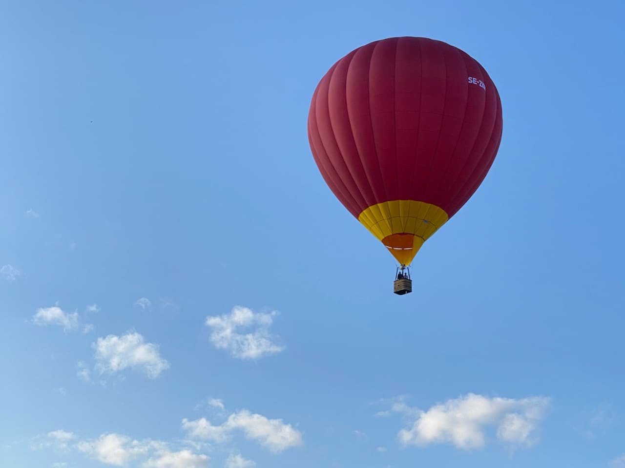 Blå ballong nerifrån mot blå himmel